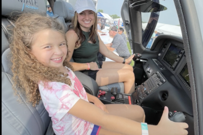 Mom and daughter sitting in plane smiling